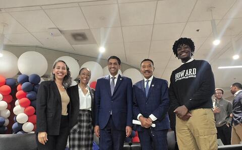 Congressional and academic leaders on stage with Nick Abram